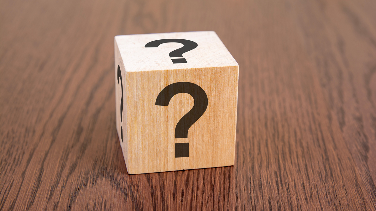 wooden blocks with question marks on wooden table, close up. space for text